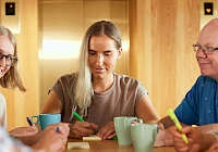 Illustration. Several people sitting and talking around a table in the office.