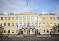 A photo of Helsinki's presidential palace with the Finnish flag it.