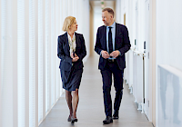 Illustration. A long light corridor with two people walking.